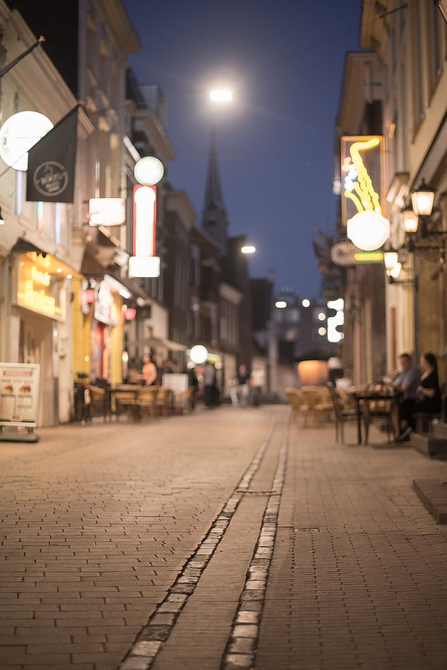 Cobblestone Street at Night with Blurred Cafe Lights