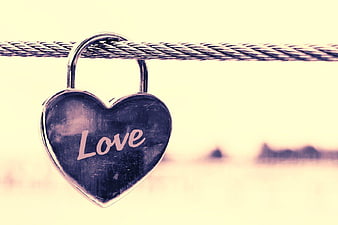 Heart-shaped padlock with love inscription on cable
