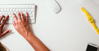 Top View of Hands Typing on White Keyboard with Yellow Watch