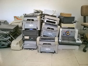 Pile of old office printers and computer equipment for recycling