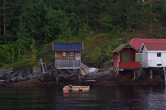 Colorful wooden boathouses on rocky Norwegian coastline