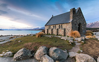 Stone Church by Lake with Snowy Mountains Background
