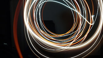 Abstract Orange and White Light Trails on Black Background