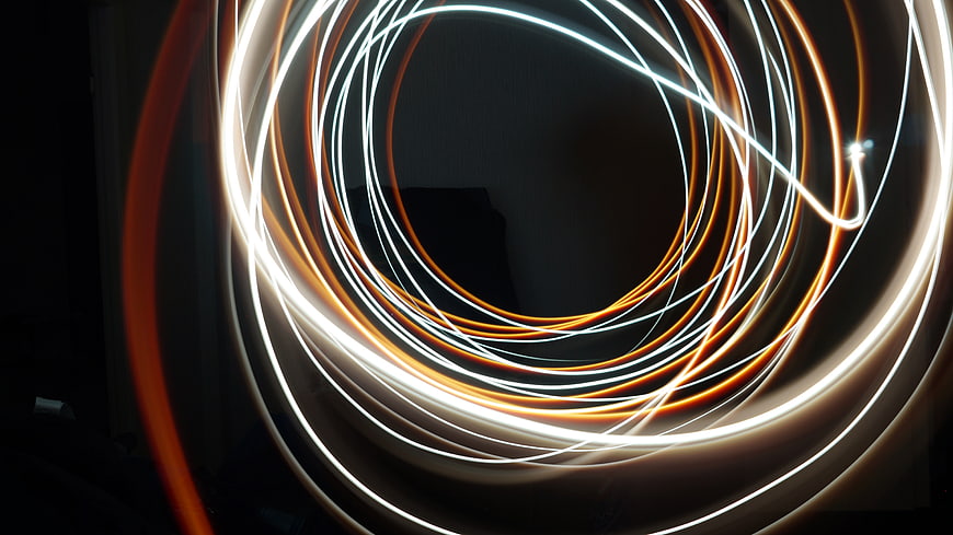 Abstract Orange and White Light Trails on Black Background