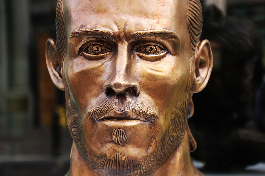 Close-up of a bronze footballer statue head with detailed facial features