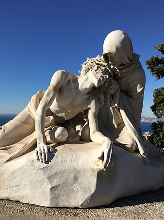 White Marble Pietà Sculpture Against Blue Sky