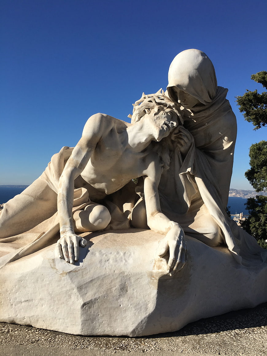 White Marble Pietà Sculpture Against Blue Sky