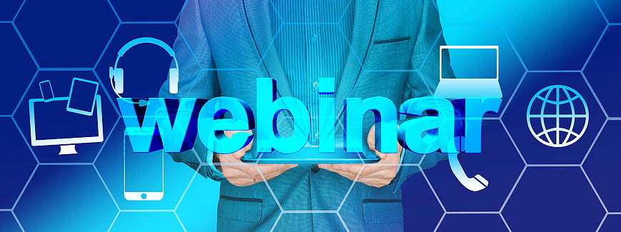 Businessman holding tablet with webinar text and digital icons