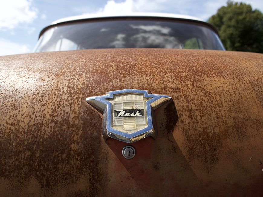Close-up of Rusty Nash Car Emblem on Vintage Trunk