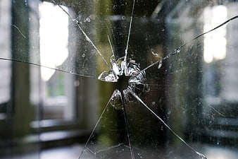Broken Glass Pane With Central Impact Hole And Radiating Cracks