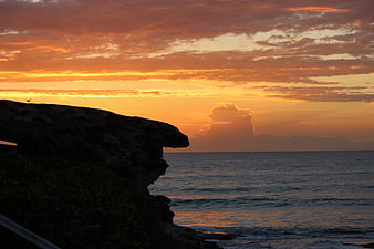 Dramatic Orange Sunset Over Ocean Cliff Silhouette