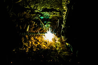 Close-up of welding sparks on steel rebar in dark environment