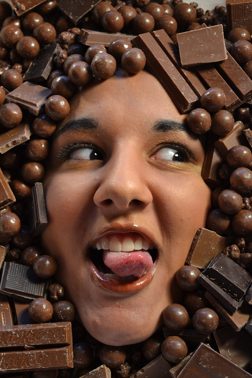 Woman face surrounded by chocolate bars and candies