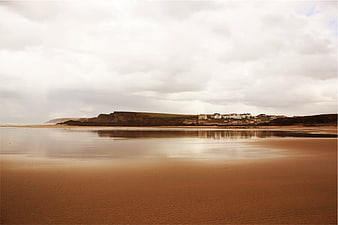 Serene Coastal Landscape with Sandy Beach and Cliffside Houses