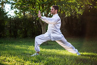 Man practicing Tai Chi in a sunlit park