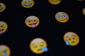 Close-up of colorful emoji faces on a dark digital screen