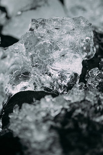 Close-up of textured ice chunk on black sand