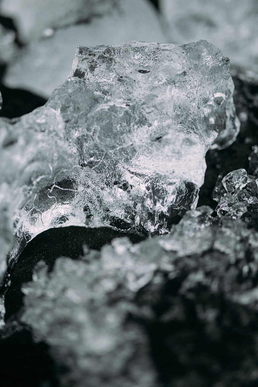 Close-up of textured ice chunk on black sand