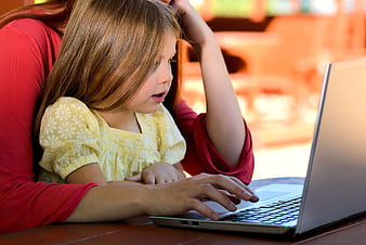 Mother and daughter using laptop together