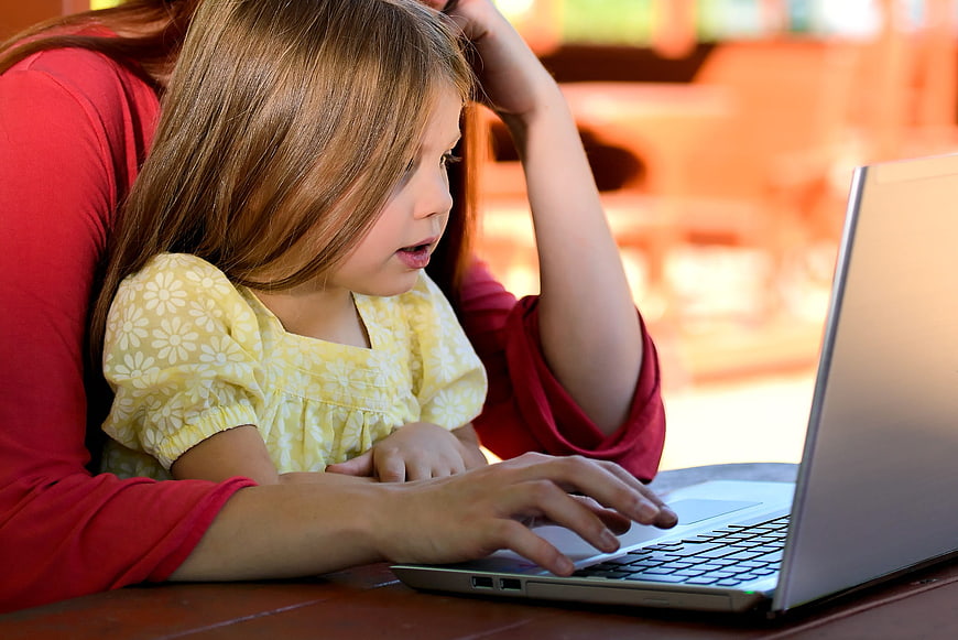 Mother and daughter using laptop together