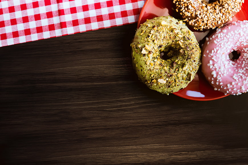 Colorful Glazed Donuts on Red Plate with Checkered Cloth
