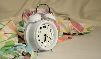 White Alarm Clock on Colorful Bedding