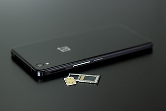 Black smartphone with SIM card tray on dark surface