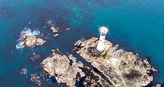 Aerial View of White Lighthouse on Rocky Coast