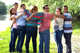 Group of friends hugging in a line outdoors