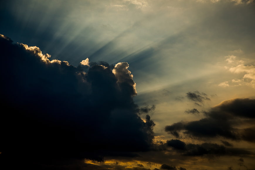 Dramatic Sun Rays Breaking Through Dark Storm Clouds