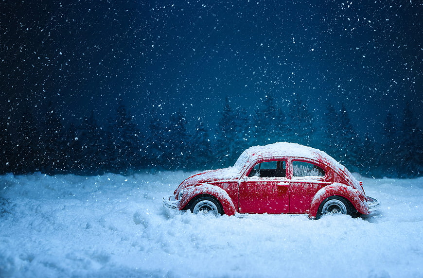 Red Vintage Toy Beetle Car in Snowy Winter Scene