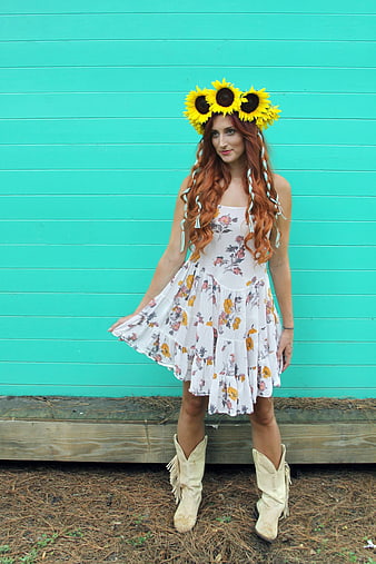 Woman in Floral Dress and Sunflower Crown Against Teal Wall