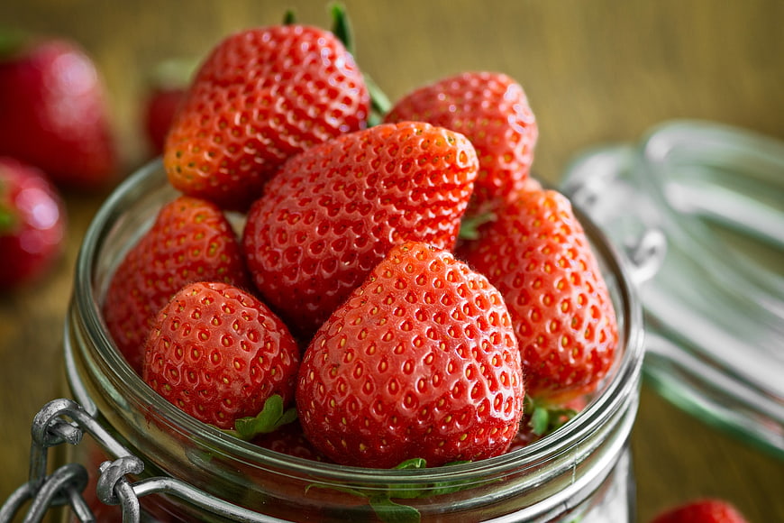 Fresh Red Strawberries in a Glass Jar on Wooden Table