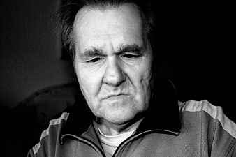 Black and white portrait of a serious older man with a furrowed brow