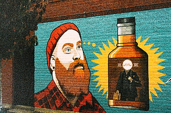 Colorful street art mural of bearded man and whiskey bottle