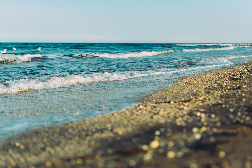 Low angle view of gentle ocean waves on pebble beach