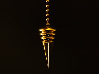 Gold Pendulum Cone Hanging on Chain Against Black Background