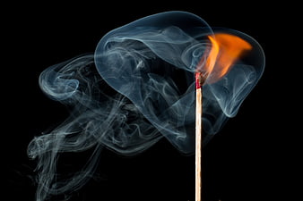 Burning Matchstick with Swirling Smoke on Black Background