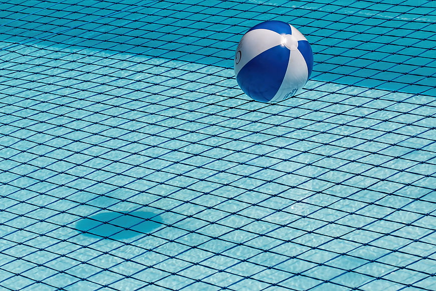 Blue and white beach ball floating in swimming pool