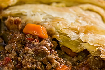 Close-up of savory meat pie with flaky pastry crust