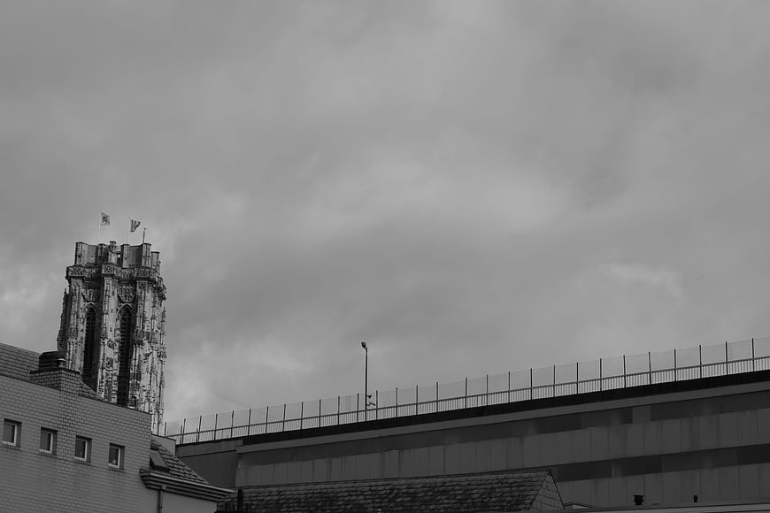 Black and white cityscape with gothic tower and overcast sky