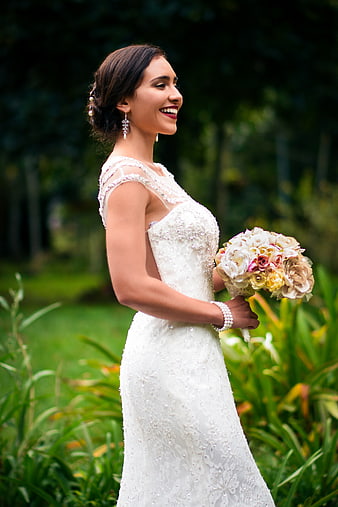 Happy Bride in Lace Wedding Dress Holding Floral Bouquet