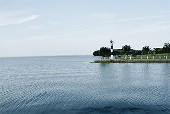 Serene coastal lighthouse on a calm blue sea horizon
