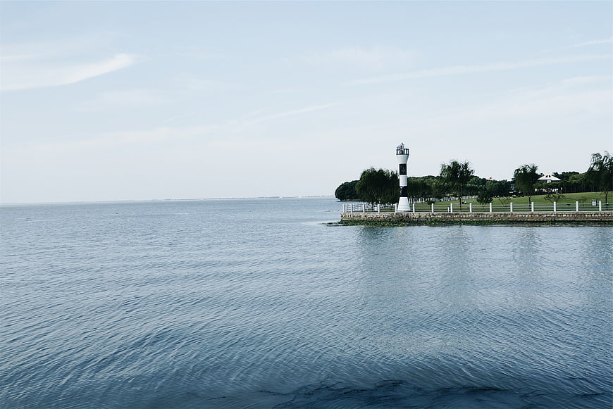 Serene coastal lighthouse on a calm blue sea horizon