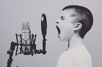 Young Boy Singing Passionately into Studio Microphone