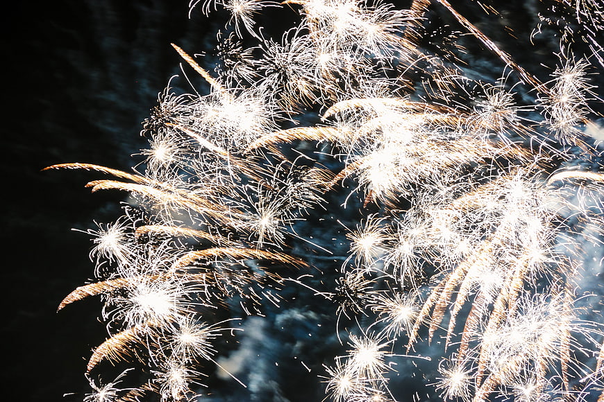 Golden fireworks exploding in the night sky