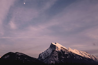 Snow-Capped Mountain Peak at Dusk with Crescent Moon