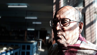Portrait of elderly man with glasses in sunlight
