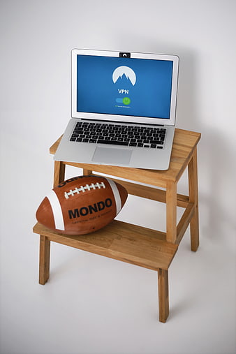 Laptop with VPN interface and football on wooden stand