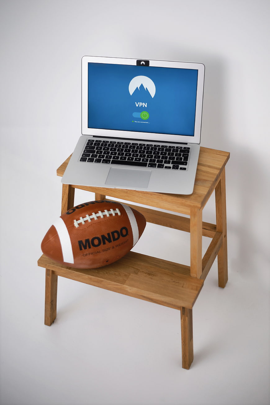 Laptop with VPN interface and football on wooden stand